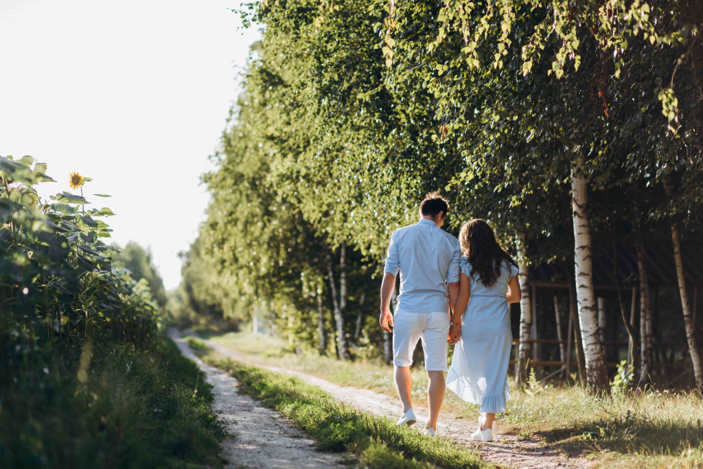 expecting-man-woman-walk-along-path-across-field-with-sunflowers (1).jpg